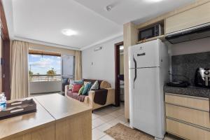 a kitchen and living room with a white refrigerator at Blue Marlim 2 quartos vista mar por Carpediem in Parnamirim