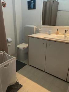 a bathroom with a sink and a toilet and a mirror at Daloba House in Costa da Caparica