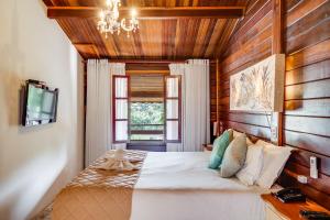 a bedroom with a large bed in a room with wooden walls at Chalés Valle Florido in Monte Verde