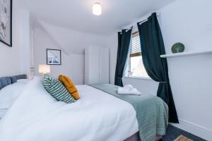 - une chambre avec un lit blanc et une fenêtre dans l'établissement Knutsford Road Moreton Wirral 3 bedroom 1 bathroom duplex apartment private parking by Rework Accommodation, à Moreton