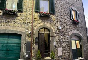 a stone building with two doors and two windows at Casa Vacanze - La Torre - Appartamento in Marta