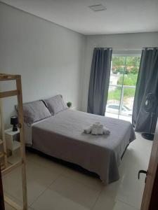 um quarto com uma cama com duas toalhas em Agradável apartamento perto da praia em Florianópolis
