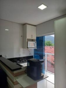 a kitchen with white cabinets and a counter top at Agradável apartamento perto da praia in Florianópolis