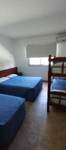 sypialnia z 2 łóżkami i oknem w obiekcie HOTEL 17 DE NOVIEMBRE w mieście Santa Teresita