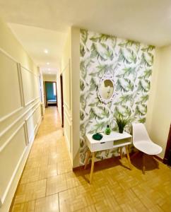 pasillo con mesa y pared con espejo en Amplio apartamento con dos patios y aparcamiento privado en Gijón