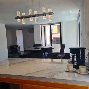 a room with a counter with chairs and a table at Casa Júpiter in Villahermosa