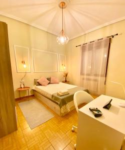 1 dormitorio con cama, mesa y escritorio en Amplio apartamento con dos patios y aparcamiento privado en Gijón