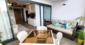 een woonkamer met een bank en een tafel en stoelen bij Poema's Beach Duplex in Arue