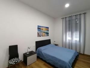 a white bedroom with a bed and a window at Calipso casa vacanza in La Spezia