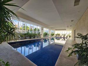 une grande piscine avec des plantes dans un bâtiment dans l'établissement Cómodo Departamento, à Mexico