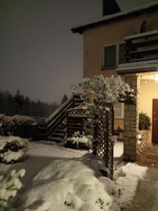 une maison avec un tas de neige devant elle dans l'établissement Pokoje gościnne Norbu, à Kudowa-Zdrój