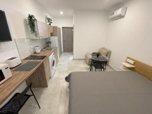 eine Küche und ein Wohnzimmer mit einem Tisch und Stühlen in der Unterkunft ARF Apartments in Emba
