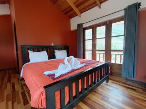 una camera da letto con un letto con pareti arancioni e una finestra di casa flores a Ollantaytambo