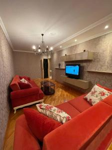 a living room with red furniture and a flat screen tv at Apartamenty u Ksyu in Pizunda