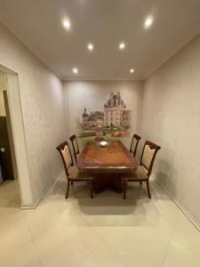 a dining room table with chairs and a painting on the wall at Apartamenty u Ksyu in Pizunda