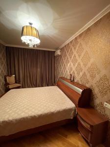 a bedroom with a bed and a chandelier at Apartamenty u Ksyu in Pizunda