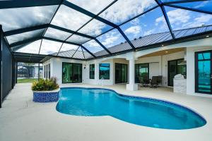 uma piscina interior numa casa com tecto de vidro em Waterfront Cape Coral Home with Pool and Boat Dock! em Cape Coral