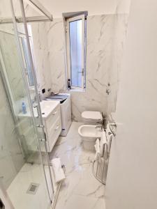 a white bathroom with a toilet and a sink at FUORI dal COMUNE in Corsico