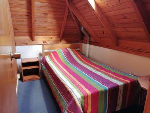 uma cama num quarto com tecto em madeira em Cabañas Altamira em Cobquecura