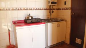 a small kitchen with a sink and a stove at Cabañas Altamira in Cobquecura