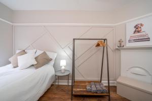 a bedroom with a bed with a mirror and a table at Stylish apartment in the heart of Kingston town centre in Kingston upon Thames