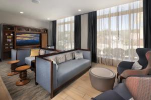 a living room with a couch and a tv at The Scenic Hotel at Biltmore Village in Asheville