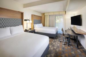 a hotel room with two beds and a desk at The Scenic Hotel at Biltmore Village in Asheville