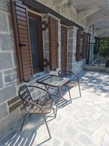 two chairs and a table on a patio at ΟΙΚΙΕΣ ΠΑΛΙΟΣ ΦΟΥΡΝΟΣ in Pramanta