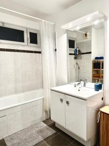 ein weißes Badezimmer mit Waschbecken und Badewanne in der Unterkunft Proche stade de France avec parking in Saint-Denis