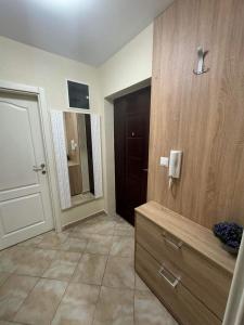 La salle de bains est pourvue d'une commode, d'un miroir et d'une porte. dans l'établissement Apartman ARENA Doboj, à Doboj