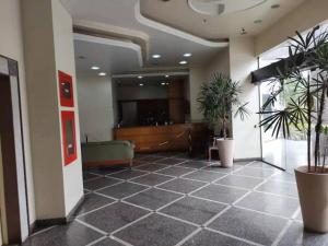 a lobby with potted plants in a building at Apto confortável, acolhedor e bem localizado in Campos dos Goytacazes