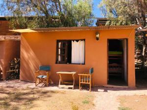 ein kleines Haus mit einem Tisch und Stühlen im Freien in der Unterkunft Familia Albahaca in Tilcara