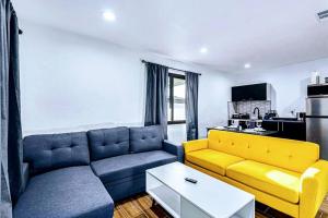 een woonkamer met een blauwe en gele bank bij Phoenix Retreat - 1 Bedroom King Suite with 2 Smart TVs - 10 min from Airp - Unit B in Phoenix