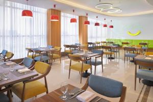 un restaurante con mesas, sillas y ventanas en Holiday Inn Jeddah Corniche, an IHG Hotel en Yeda