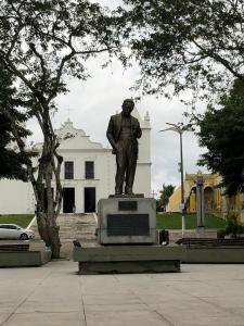 Eine Statue eines Mannes vor einem weißen Gebäude. in der Unterkunft Casa de Serra Vila Viçosa in Viçosa do Ceará