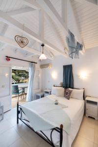 a bedroom with a large bed and a table at Hotel Selini in Agios Nikitas