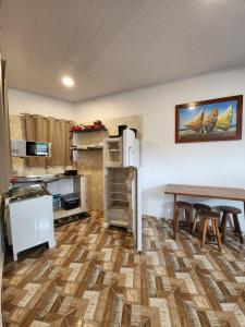 Habitación con cocina con mesa y nevera. en Hospedaria Ilhabela - Flats Balsa, en Ilhabela