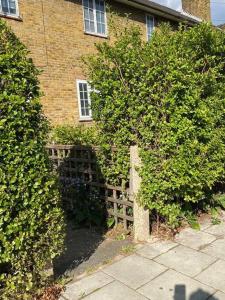 een stenen huis met een hek ervoor bij One bedroom Putney Village flat in Londen