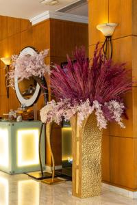 a vase with purple flowers in a room at Radisson Blu Martinez Beirut in Beirut