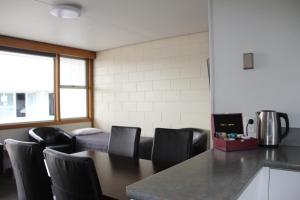 a dining room with a table and black chairs at Charlton Motel in Gore