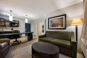 a living room with a couch and a desk at Sonesta Simply Suites Huntsville Research Park in Huntsville