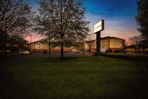 Sonesta Simply Suites Huntsville Research Park في هانتسفيل: علامة في العشب أمام المبنى
