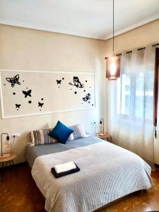 1 dormitorio con 1 cama con mariposas en la pared en Amplio apartamento con dos patios y aparcamiento privado en Gijón
