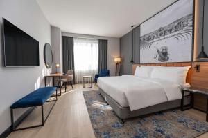 a hotel room with a large bed and a desk at Radisson Blu Hotel, Amman Galleria Mall in Amman
