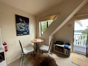 a living room with a table and chairs and a staircase at The Jazz Loft in Onetangi