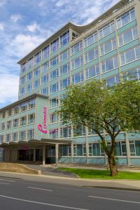 un gran edificio azul con una señal rosa en él en prizeotel Dortmund-City, en Dortmund