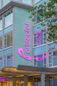 a building with a neon sign on the side of it at prizeotel Dortmund-City in Dortmund