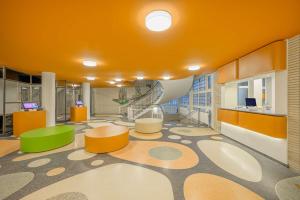 una oficina con techos naranjas, mesas y sillas naranjas en prizeotel Dortmund-City en Dortmund
