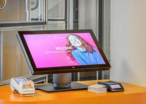 ドルトムントにあるPrize by Radisson, Dortmund Cityのテーブルの上に置かれたコンピューターのモニターと電話
