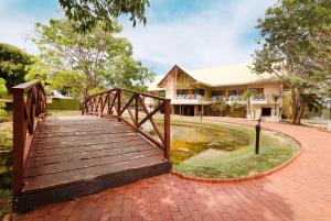 契特雷的住宿－Hotel Faranda Guayacanes, a member of Radisson Individuals，一座建在一座建筑前面的池塘上的木桥